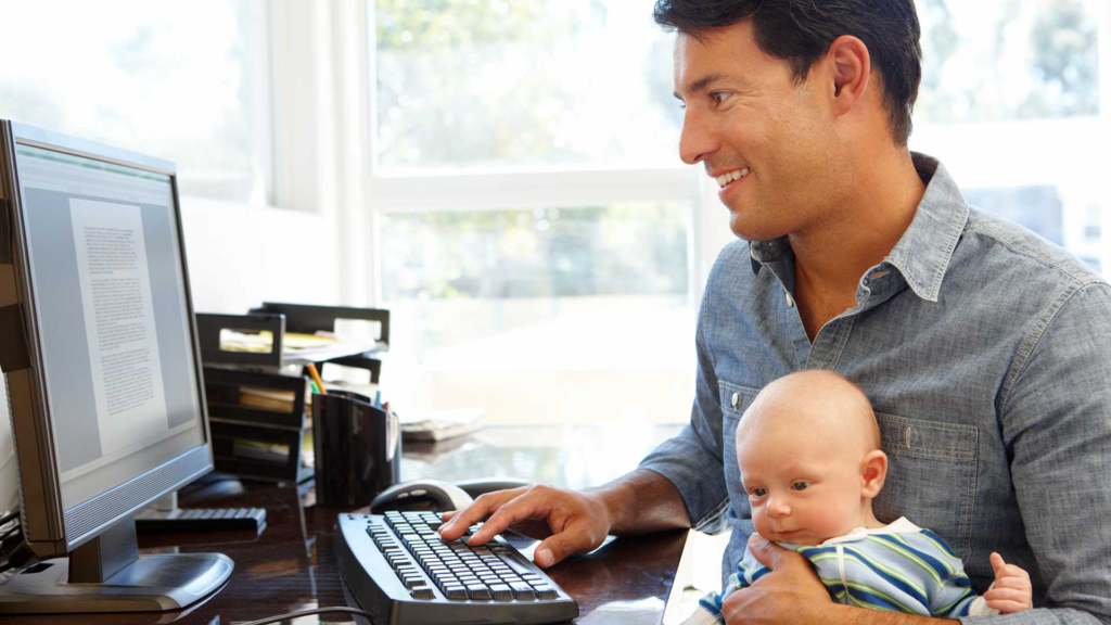 Mann, der mit Baby in den Armen arbeitet. Dies ist natürlich viel besser für die Gesundheit der Bevölkerung. Die Mitarbeiter verbringen mehr Zeit mit der Familie und genießen mehr Flexibilität, um Arbeit und Leben in Einklang zu bringen.